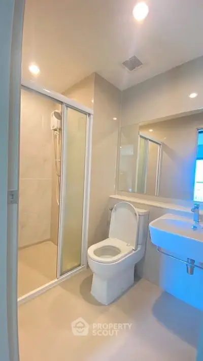 Modern bathroom with shower and sleek fixtures in a contemporary apartment.