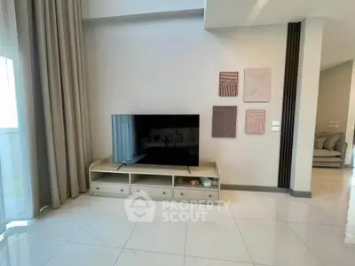 Modern living room with sleek TV setup and elegant decor in a bright, spacious apartment.