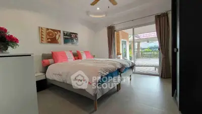 Spacious bedroom with balcony access and scenic view, perfect for relaxation.
