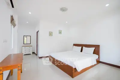 Spacious and bright bedroom with modern furnishings and minimalist decor.