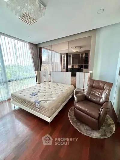 Luxurious bedroom with elegant decor and large windows offering natural light.