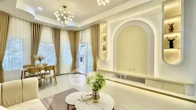 Elegant living room with modern decor and dining area, featuring stylish lighting and large windows.