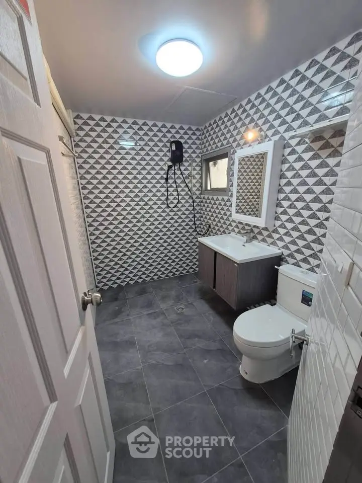 Modern bathroom with geometric tile design and sleek fixtures