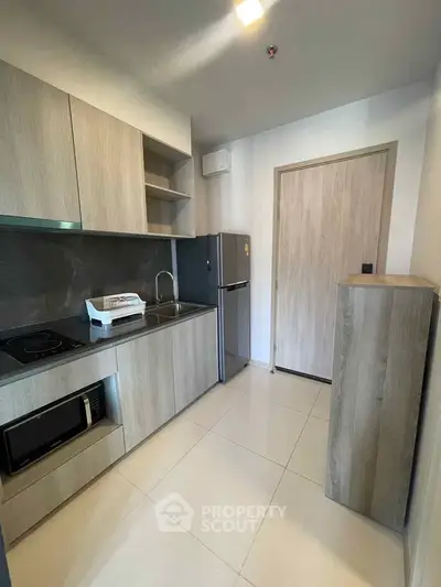 Modern kitchen with sleek cabinetry and appliances in a compact layout.