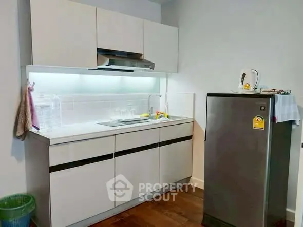 Modern compact kitchen with sleek cabinetry and stainless steel appliances.