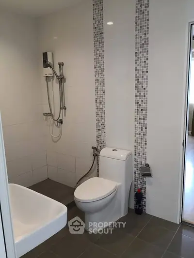 Modern bathroom with sleek shower and toilet in contemporary apartment.