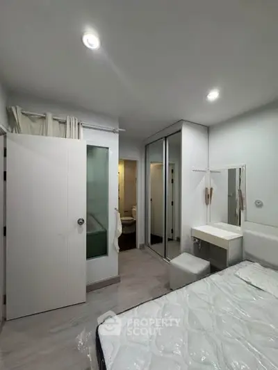 Modern bedroom with ensuite bathroom and mirrored closet doors