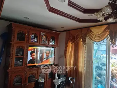 Spacious living room with elegant wooden furniture and large windows for natural light.
