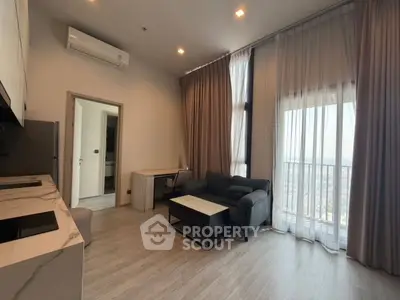 Modern living room with large windows and stylish furniture in a high-rise apartment.