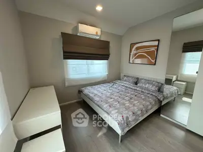 Modern bedroom with stylish decor and ample natural light, featuring a comfortable bed and sleek furnishings.