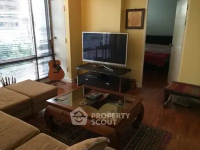 Cozy living room with natural light, modern furniture, and a guitar for a homely touch.