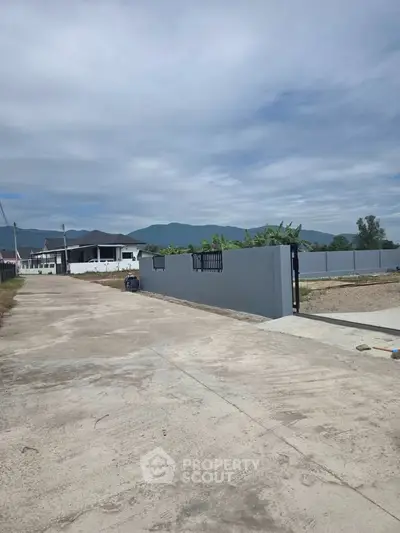 Spacious property entrance with mountain views and modern fencing