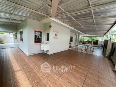 Spacious covered patio with wooden flooring and outdoor seating area