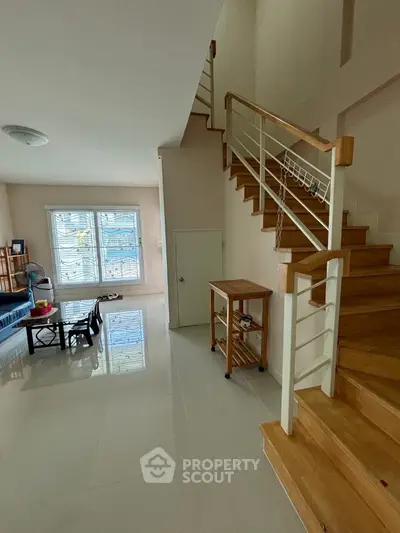 Spacious living area with modern staircase and natural light