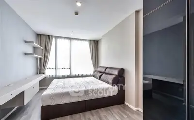 Modern minimalist bedroom with sleek design and large window for natural light.