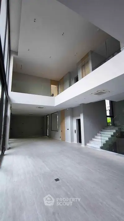 Spacious modern living room with high ceilings and sleek staircase