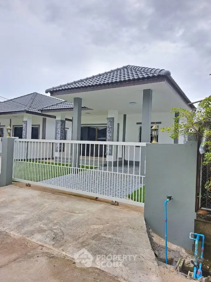 Charming modern house with tiled roof and gated entrance, perfect for family living.