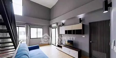 Modern living room with high ceiling and stylish decor in a contemporary apartment.