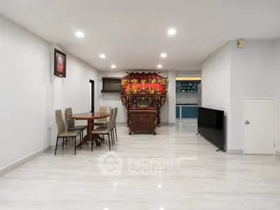 Spacious living room with modern decor and unique traditional altar, perfect for family gatherings.