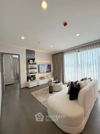 Modern living room with elegant decor and large windows offering natural light.