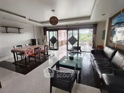 Spacious living room with modern furniture and large windows opening to a balcony.