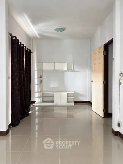 Spacious empty room with glossy tiled floor and modern shelving unit