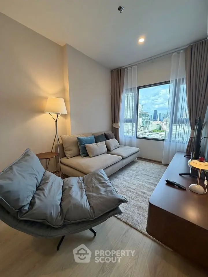 Modern living room with city view, cozy seating, and stylish decor in a high-rise apartment.