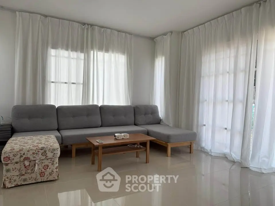 Spacious living room with modern gray sectional sofa and natural light