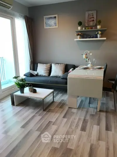 Modern living room with stylish decor and natural light, featuring a cozy sofa and sleek dining area.