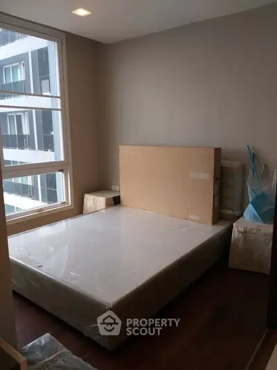 Cozy bedroom with large window and new mattress in modern apartment