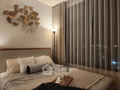 Cozy bedroom with elegant decor and large window offering stunning night views.