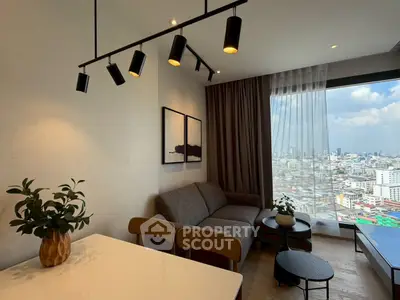 Modern living room with city view, stylish lighting, and cozy seating area.