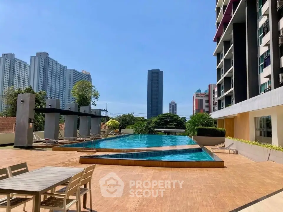 Luxurious rooftop pool with city skyline views in modern apartment complex.