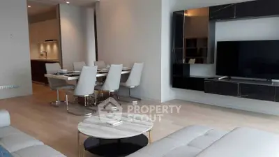 Modern living room with sleek furniture and open dining area, perfect for contemporary living.