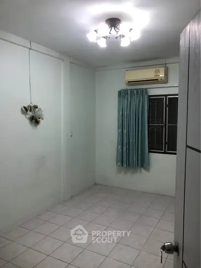 Cozy empty room with air conditioning and tiled floor, ready for customization.