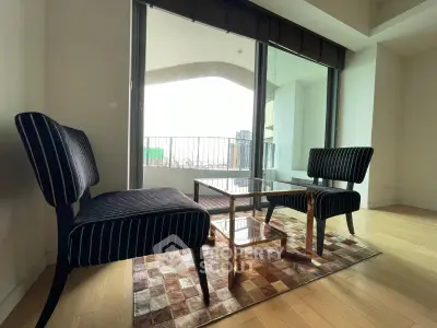 Stylish living room with modern furniture and balcony view in a high-rise apartment.