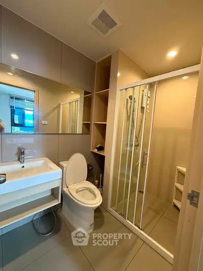 Modern bathroom with glass shower and sleek fixtures in a contemporary apartment.