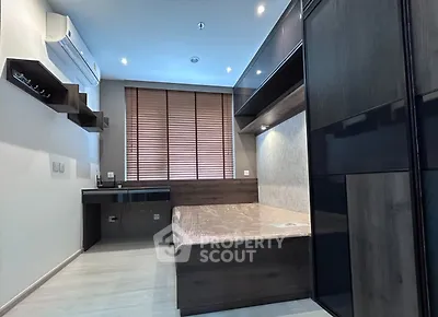 Modern bedroom with sleek design, built-in shelves, and air conditioning unit.