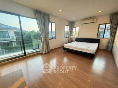 Spacious bedroom with large windows and balcony access in modern home