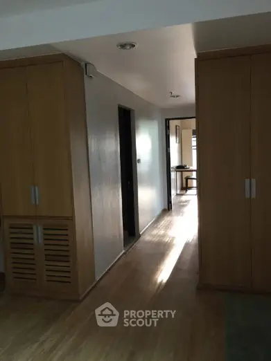 Spacious hallway with wooden flooring and built-in storage cabinets