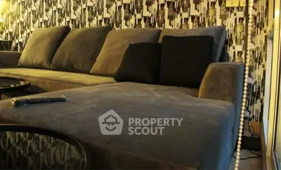Stylish modern living room with plush gray sofa and artistic wallpaper.