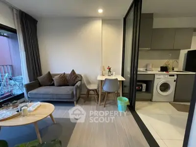 Modern open-plan living room with cozy seating and compact kitchen area.