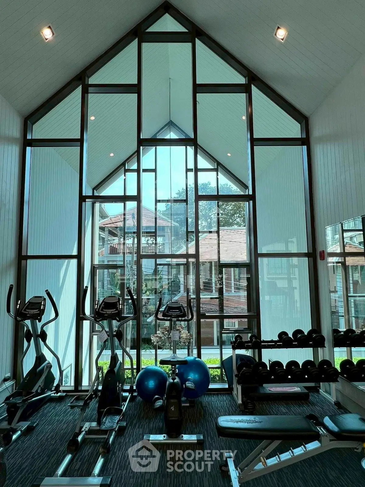 Stunning gym with floor-to-ceiling windows and modern equipment in a luxury residential complex.