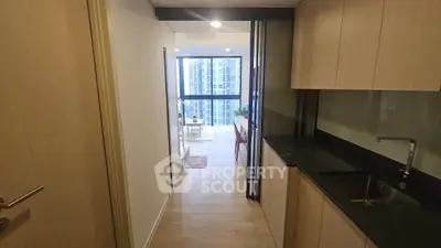 Modern apartment hallway leading to a bright living area with city view.
