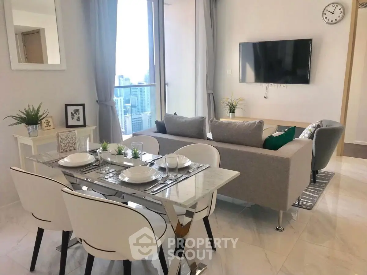 Modern living room with dining area and city view, featuring sleek furniture and decor.