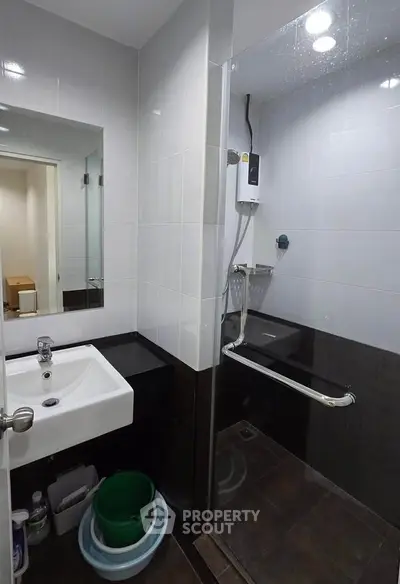 Modern bathroom with sleek shower and stylish sink in contemporary apartment.