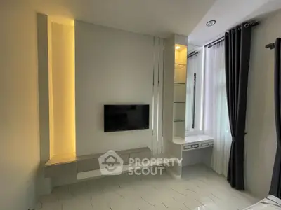 Modern living room with built-in TV unit and elegant curtains