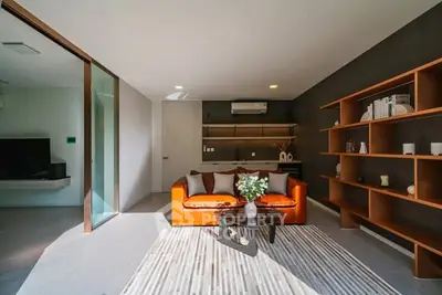 Modern living room with stylish orange sofa and open shelving