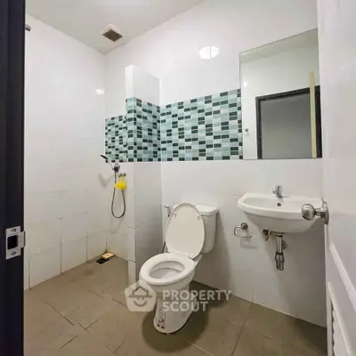 Modern bathroom with tiled walls and compact fixtures
