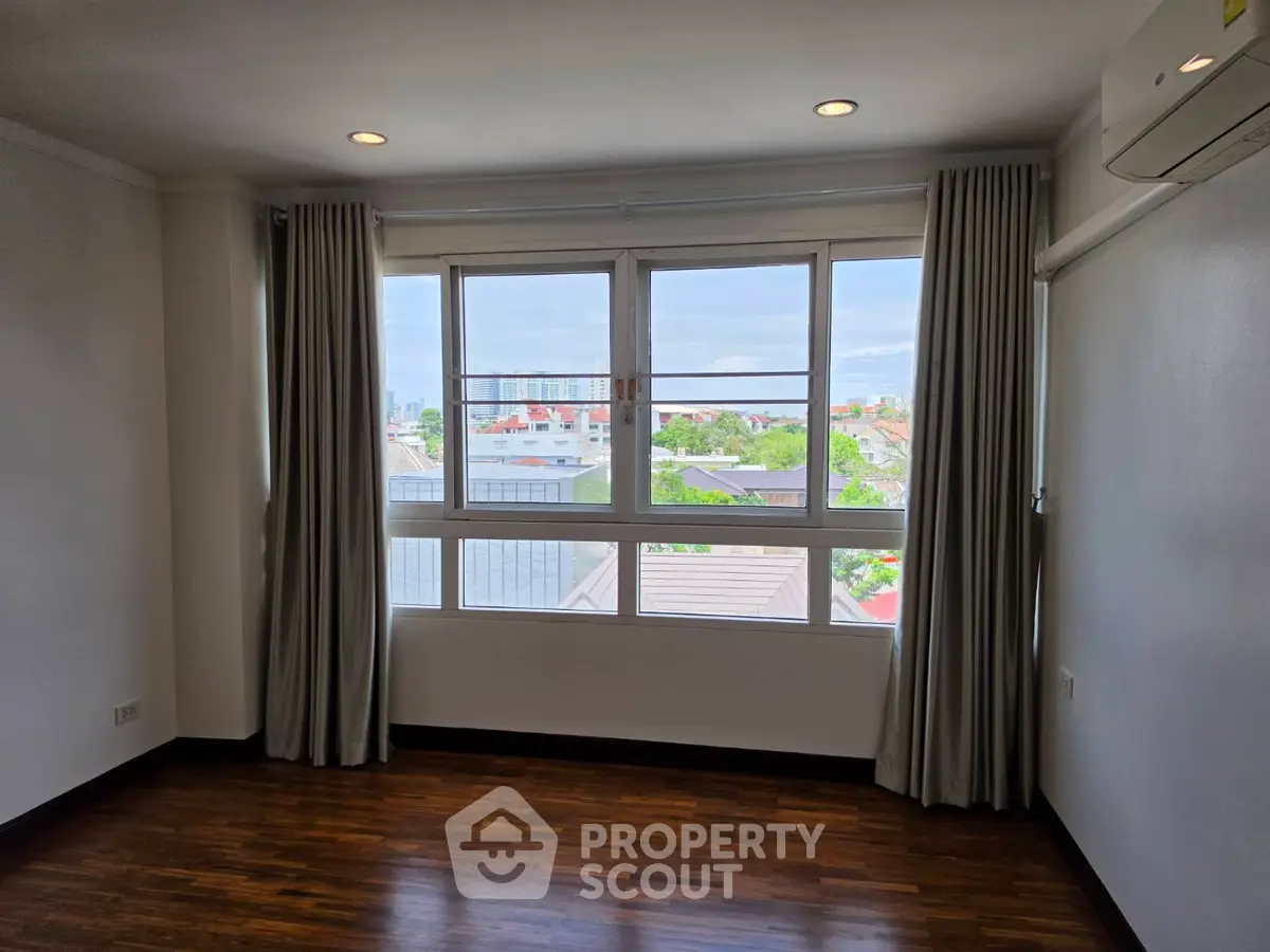 Spacious room with large windows offering a stunning city view, perfect for natural light lovers.